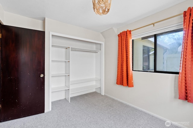 unfurnished bedroom with carpet flooring, a closet, and baseboards