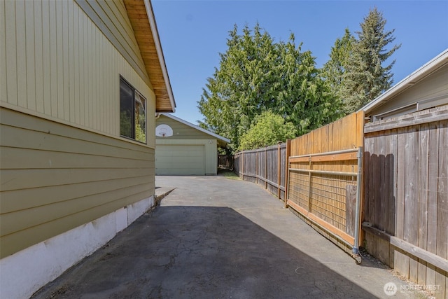 view of patio featuring concrete driveway and fence