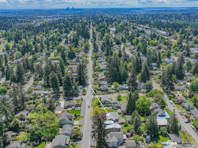 view of property location featuring nearby suburban area and a forest