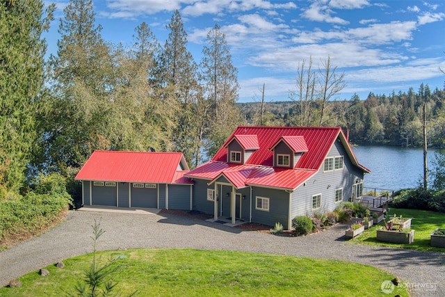 893 Snow Creek Rd, Quilcene, WA 98376 - view of front of house with gravel driveway, a water view, a garage, a front lawn, and metal roof