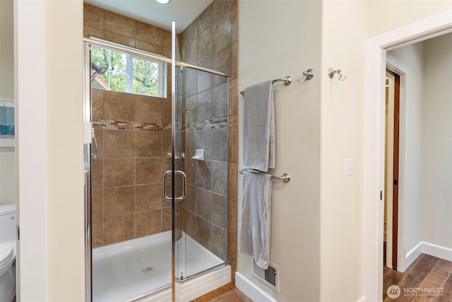 893 Snow Creek Rd, Quilcene, WA 98376 - bathroom featuring toilet, a stall shower, baseboards, and wood finished floors