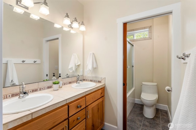 893 Snow Creek Rd, Quilcene, WA 98376 - full bath featuring double vanity, tile patterned floors, toilet, and bath / shower combo with glass door