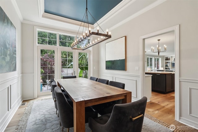 2947 275th Ave SE, Sammamish, WA 98075 - dining room with a chandelier, crown molding, a decorative wall, light wood finished floors, and a wainscoted wall