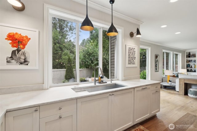 2947 275th Ave SE, Sammamish, WA 98075 - kitchen with a sink, crown molding, pendant lighting, light wood-type flooring, and light countertops