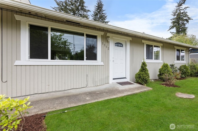 view of exterior entry with a lawn