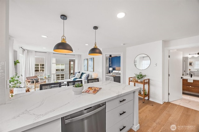 323 Queen Anne Ave N Unit 502, Seattle, WA 98109 - kitchen with dishwasher, white cabinets, decorative light fixtures, light wood-type flooring, and light stone countertops