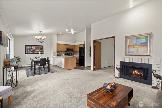living room with vaulted ceiling, a chandelier, light carpet, a brick fireplace, and recessed lighting
