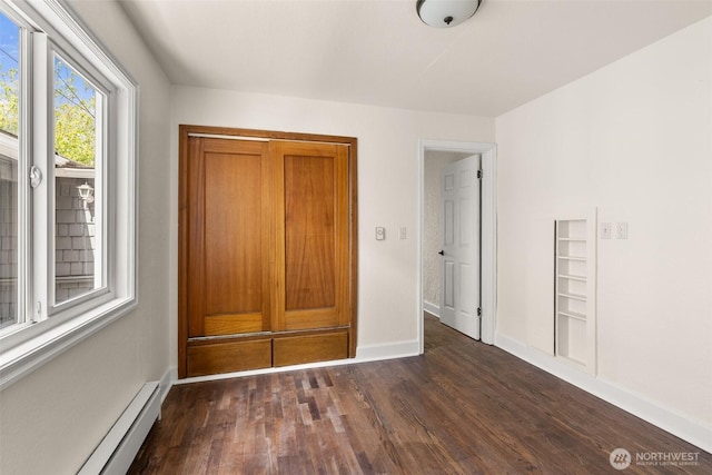 17291725 5th Ave SE, Olympia, WA 98501 - unfurnished bedroom featuring a baseboard heating unit, dark wood finished floors, and baseboards