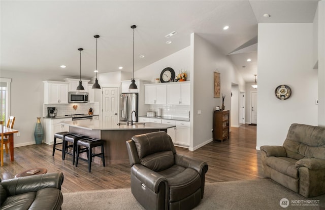 11975 NE Neppel Rd, Moses Lake, WA 98837 - living room featuring dark wood-type flooring, recessed lighting, vaulted ceiling, and baseboards