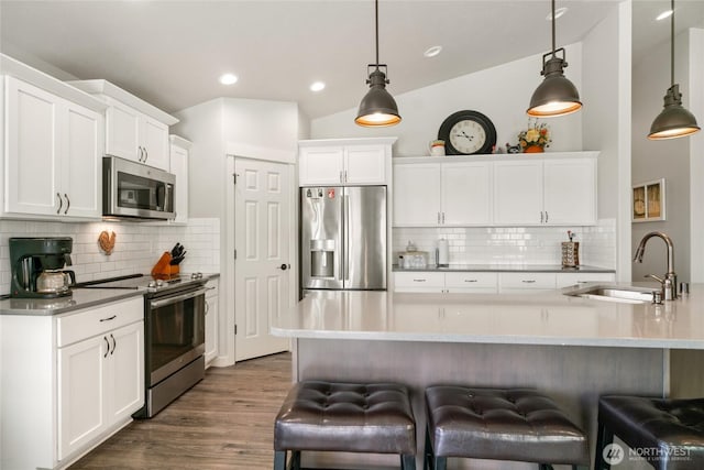 11975 NE Neppel Rd, Moses Lake, WA 98837 - kitchen featuring stainless steel appliances, a sink, white cabinetry, a breakfast bar area, and backsplash