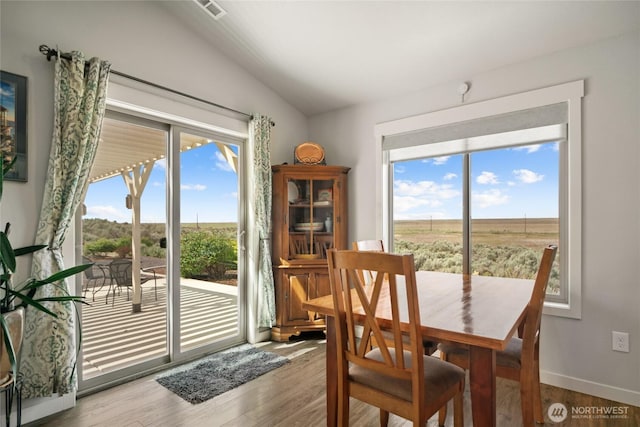 11975 NE Neppel Rd, Moses Lake, WA 98837 - dining room featuring healthy amount of natural light, vaulted ceiling, wood finished floors, and baseboards