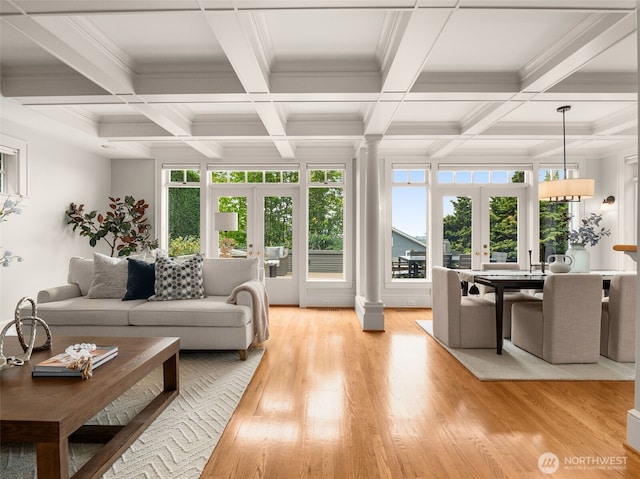 living area featuring french doors, decorative columns, beam ceiling, light wood-style floors, and coffered ceiling