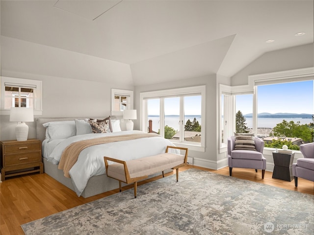 bedroom with lofted ceiling, wood finished floors, a water view, recessed lighting, and baseboards