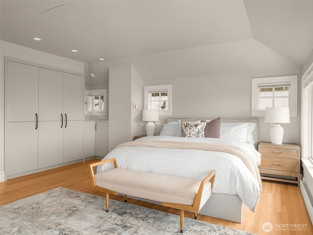 bedroom with multiple windows, light wood-style flooring, a closet, recessed lighting, and vaulted ceiling