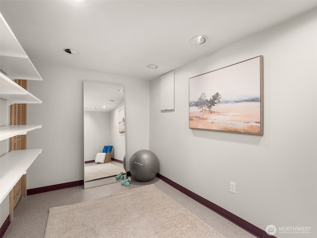 exercise area featuring baseboards and recessed lighting