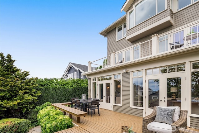 wooden deck featuring outdoor dining space and french doors