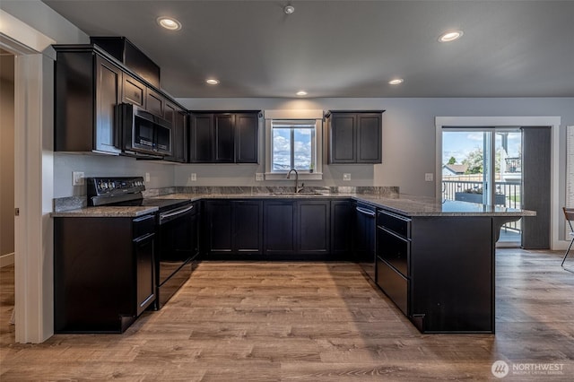 2436 Berkley Loop, East Wenatchee, WA 98802 - kitchen with black appliances, a peninsula, a sink, stone countertops, and light wood finished floors