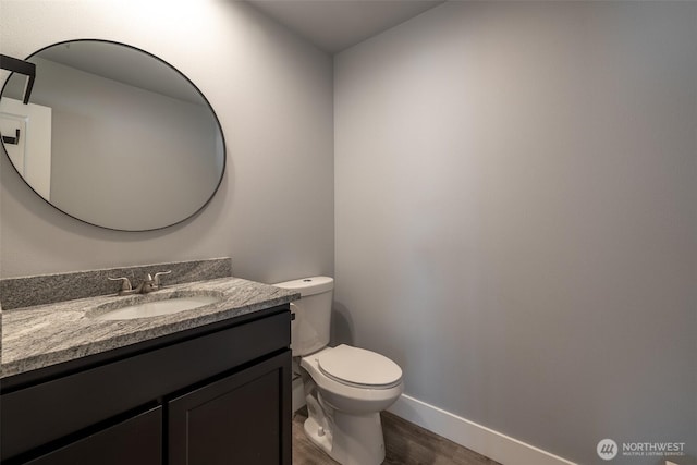 2436 Berkley Loop, East Wenatchee, WA 98802 - half bathroom with wood finished floors, toilet, vanity, and baseboards
