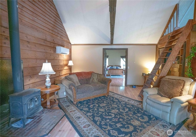 285 Pete Beck Rd, Quilcene, WA 98376 - living room with vaulted ceiling, wood finished floors, wood walls, and a wood stove