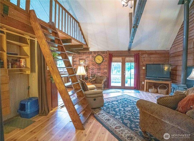285 Pete Beck Rd, Quilcene, WA 98376 - living room featuring hardwood / wood-style floors, stairway, high vaulted ceiling, wooden walls, and french doors