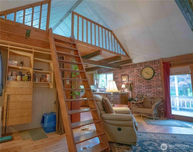 285 Pete Beck Rd, Quilcene, WA 98376 - living room featuring wood finished floors, high vaulted ceiling, stairway, and a wood stove