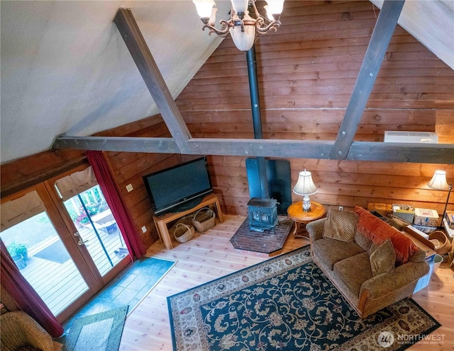 285 Pete Beck Rd, Quilcene, WA 98376 - living room with a wood stove, wooden walls, wood finished floors, vaulted ceiling, and a chandelier