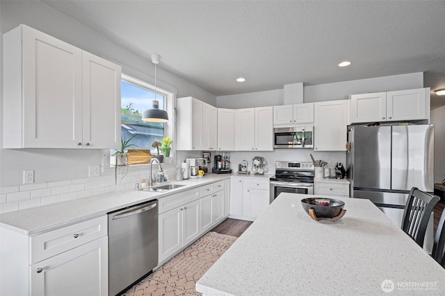 817 B St, Vader, WA 98593 - kitchen with stainless steel appliances, a sink, recessed lighting, white cabinetry, and light stone counters