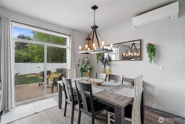817 B St, Vader, WA 98593 - dining space with a chandelier, a wall mounted AC, light wood-style floors, and baseboards