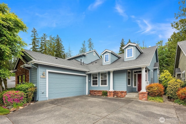 view of front facade featuring an attached garage, concrete driveway, and roof with shingles