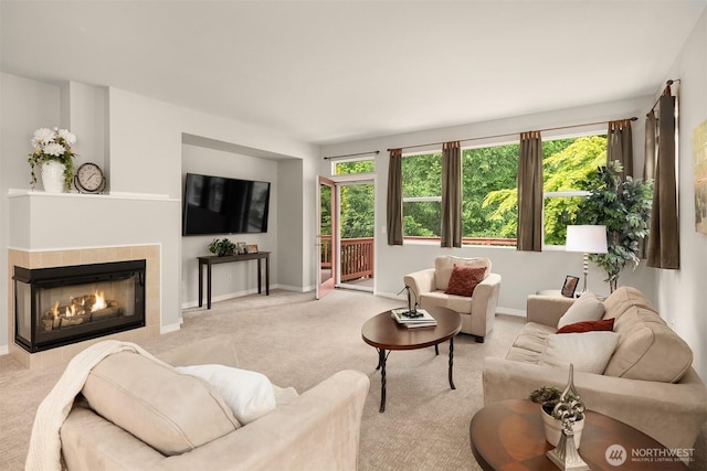 living area with carpet, plenty of natural light, baseboards, and a tile fireplace