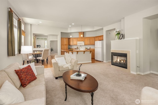 living room with recessed lighting, baseboards, light colored carpet, and a fireplace