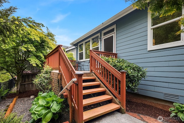 wooden terrace featuring fence and stairway