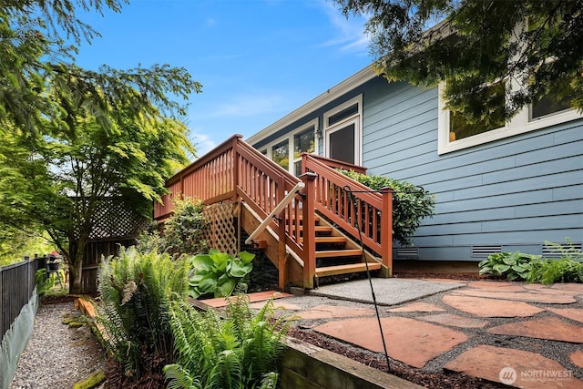 back of property with a deck, fence, a patio area, stairway, and crawl space