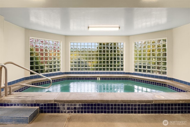 view of swimming pool featuring a hot tub