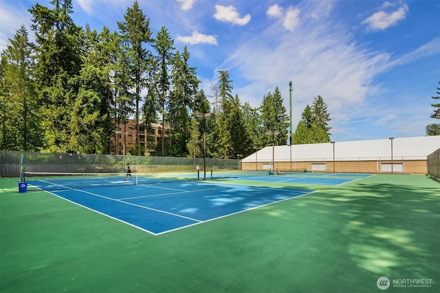 view of tennis court featuring fence