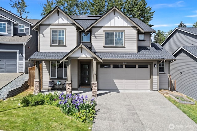 craftsman house with board and batten siding, driveway, a shingled roof, and solar panels
