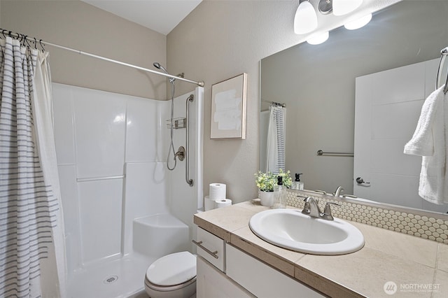 bathroom featuring curtained shower, vanity, and toilet