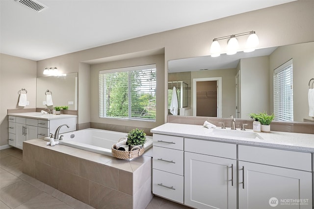 bathroom with tile patterned flooring, plenty of natural light, and a garden tub
