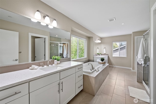 full bath featuring a stall shower, a garden tub, tile patterned flooring, vanity, and baseboards