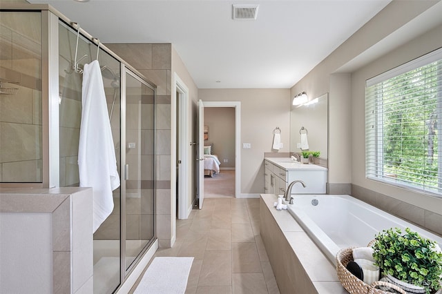 full bath with plenty of natural light, a stall shower, and a garden tub