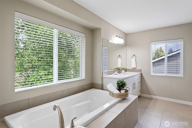 bathroom featuring a bath, vanity, tile patterned floors, and baseboards