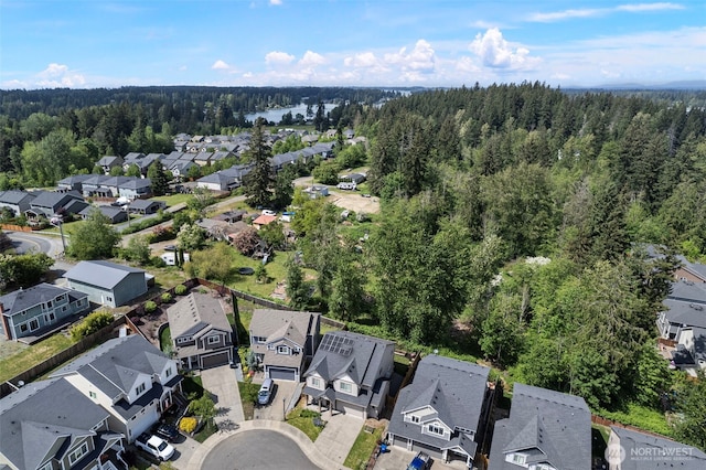 view of property location with a forest and nearby suburban area