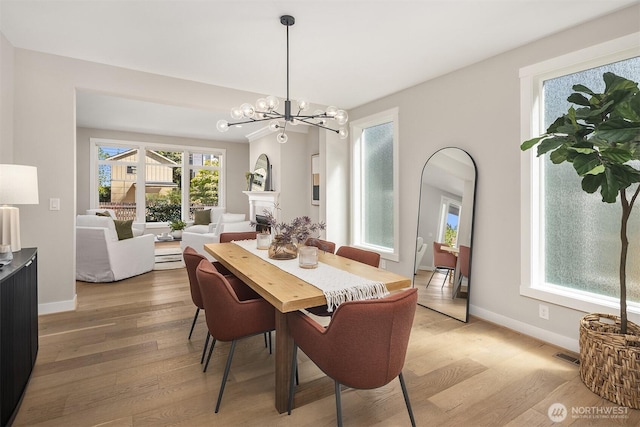 3815 NE 89th St, Seattle, WA 98115 - dining room featuring light wood finished floors, baseboards, a chandelier, and arched walkways