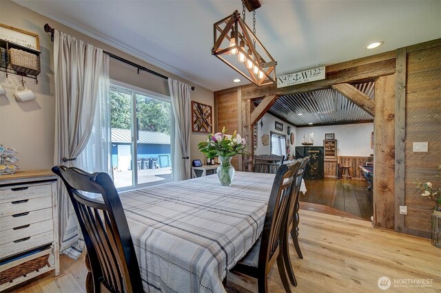 dining space with wood finished floors, wooden walls, and recessed lighting
