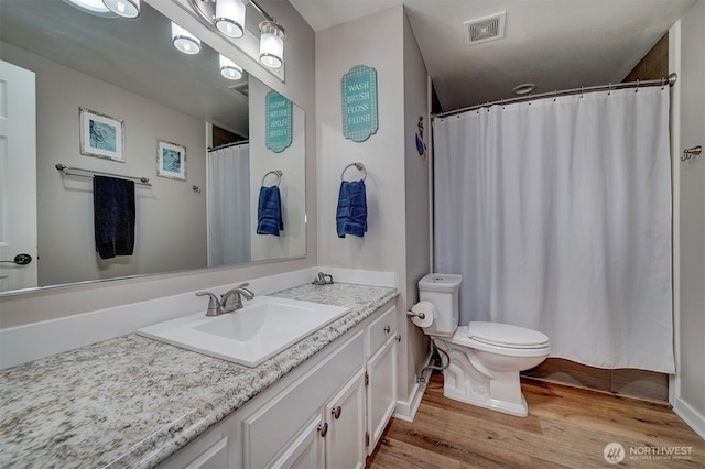 full bath featuring wood finished floors, toilet, and vanity