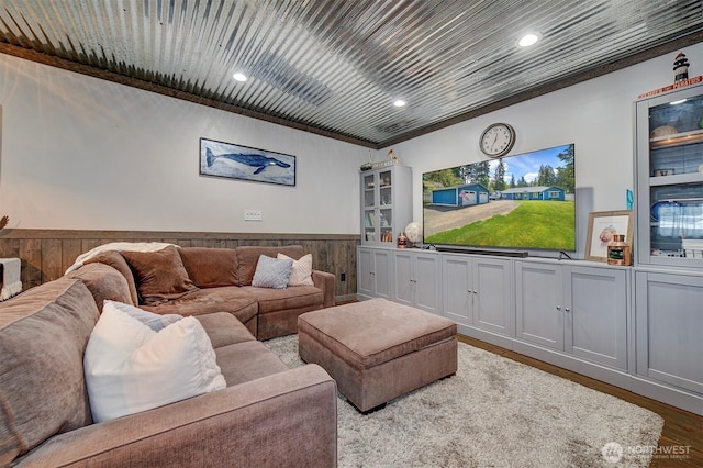 living room with wainscoting, wood walls, wood finished floors, recessed lighting, and crown molding