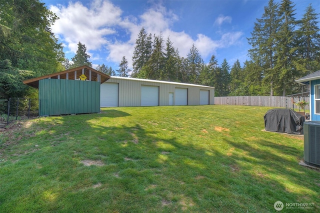 view of yard featuring a garage, an outbuilding, and central AC unit