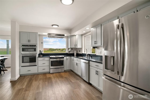 12062 Neppel Rd, Moses Lake, WA 98837 - kitchen with stainless steel appliances, a sink, dark countertops, wood finished floors, and recessed lighting