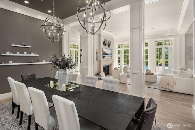4207 Holly Ln, Mercer Island, WA 98040 - dining room with a chandelier, crown molding, light wood-style flooring, recessed lighting, and a lit fireplace