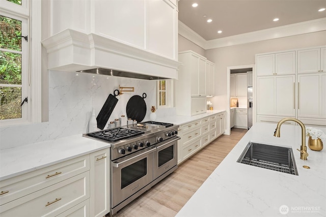 4207 Holly Ln, Mercer Island, WA 98040 - kitchen featuring appliances with stainless steel finishes, a sink, premium range hood, backsplash, and white cabinetry